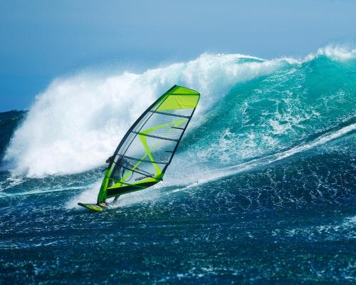 a person riding a wave in the ocean with a sail at Bahia Residence Cabarete in Cabarete