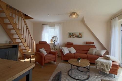 a living room with a couch and a staircase at PM09 KüstenReich in Wremen