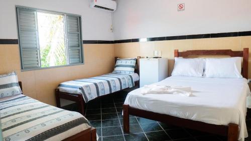 a room with two twin beds and a window at Hotel Oasis 2 in Conceição do Araguaia