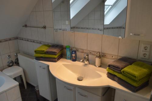 a bathroom with a sink and a mirror and towels at Ferienwohnung Holzberger in Goslar