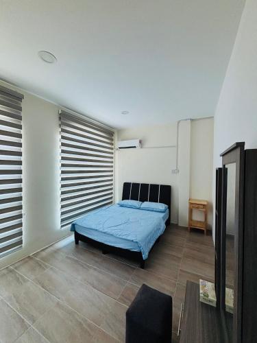 a bedroom with a blue bed in a room at May Ong Guest House in Taiping