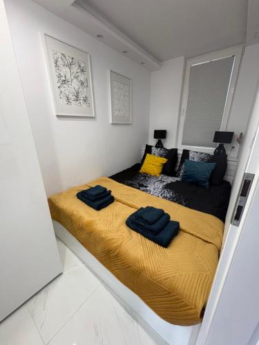 two beds in a white room with yellow sheets at Luksusowy Apartament Giżycko in Giżycko