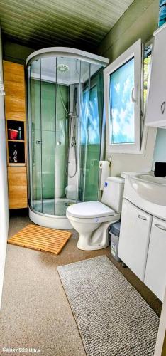 a bathroom with a toilet and a glass shower at SAK Mobile Home Privlaka in Privlaka