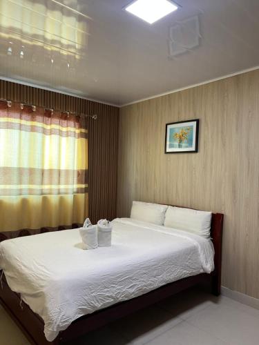 a bedroom with a bed with two towels on it at Hotel Cristina in Bocas Town