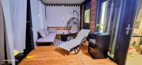 a balcony with a couch and a chair in a room at SAK Mobile Home Privlaka in Privlaka