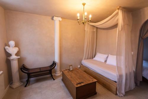 a bedroom with a canopy bed with a wooden table at Villa Hermès in La Flocellière