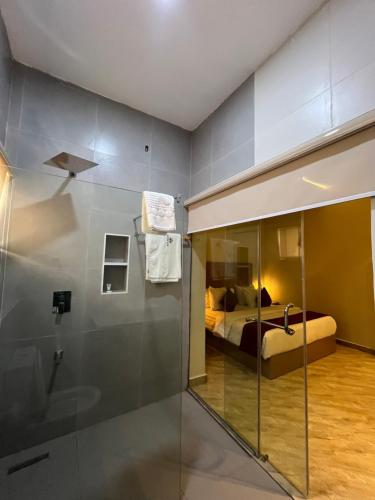 a bathroom with a shower and a bed in a room at Teestone Hotels and Apartment Ikeja in Lagos