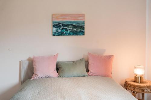 a bedroom with a bed with pink and blue pillows at Stivolles Ambiente in Niendorf! in Hamburg