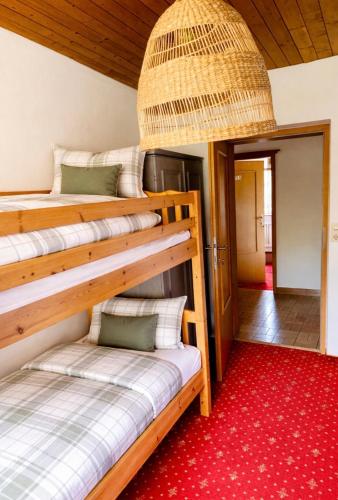a room with two bunk beds and a red carpet at Frühstückspension Waldeck in Mayrhofen