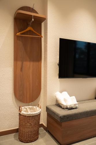 a room with a flat screen tv and a basket at Than Coffee & Homestay in Hai Phong