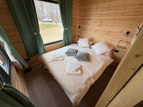 a bed in a wooden room with a window at The Little House in Sohodol