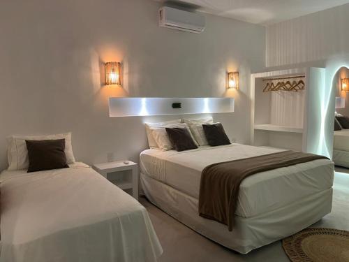 a bedroom with two beds and lights on the wall at Casa Ninho in Atins