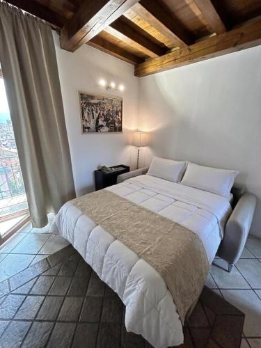 a bedroom with a large white bed and a window at Casa Renoir appartamento a due passi dal lago in Verbania