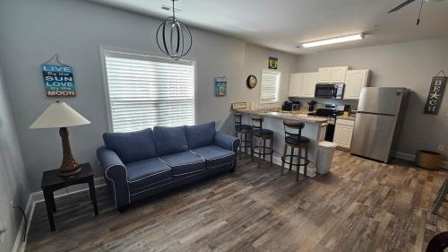 a living room with a blue couch and a kitchen at Charming Condo 2min Walk From The Famous Boardwalk in Myrtle Beach