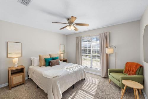 a bedroom with a bed and a green chair at Aggie Game Day Walk to A&M - Kings - Outdoor in College Station