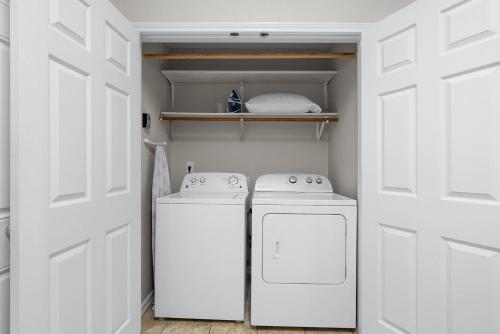 a white kitchen with two washers and a refrigerator at Aggie Game Day Walk to A&M - Kings - Outdoor in College Station