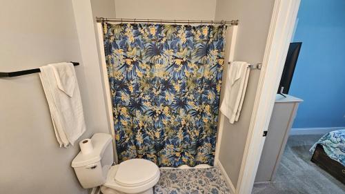 a bathroom with a shower curtain and a toilet at Charming Condo 2min Walk From The Famous Boardwalk in Myrtle Beach