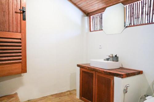 a bathroom with a sink and a mirror at Villa Ombak in Katiet