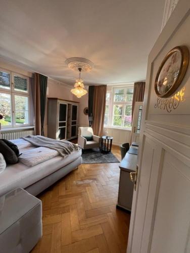 a bedroom with a bed and a living room at Hotel Garni Villa Rosengarten in Überlingen