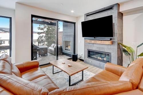 a living room with a couch and a fireplace at Downtown WP River Front Villa 242 I Private Hot Tub I Great Views in Winter Park