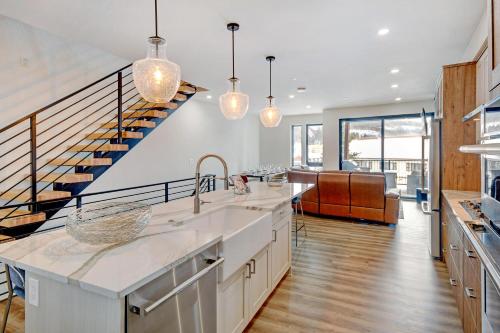 a kitchen with a sink and a staircase at Downtown WP River Front Villa 242 I Private Hot Tub I Great Views in Winter Park