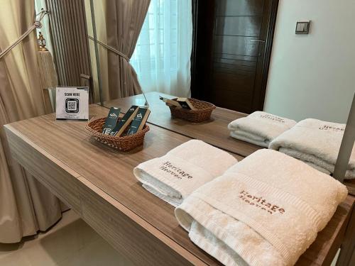 a bathroom counter with towels and a mirror at Heritage Heaven by Premium Suites in Karachi