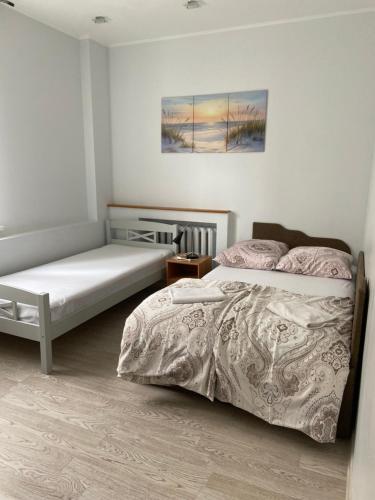 a bedroom with two beds and a painting on the wall at Imanta Apartment in Daugavpils