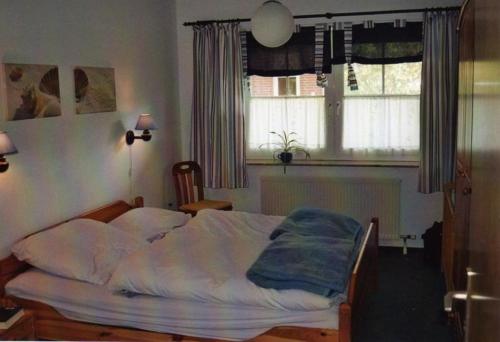 a bedroom with a bed in front of a window at FeWo-mit-Terasse-u-Garten-am-Golfplatz in Wulfen auf Fehmarn