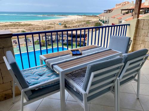 a table and chairs on a balcony with a view of the beach at Seaview Luxury Penthouse Mare in Sal Rei
