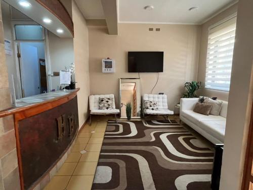 a living room with a couch and a tv at Hotel Brasil in Antofagasta