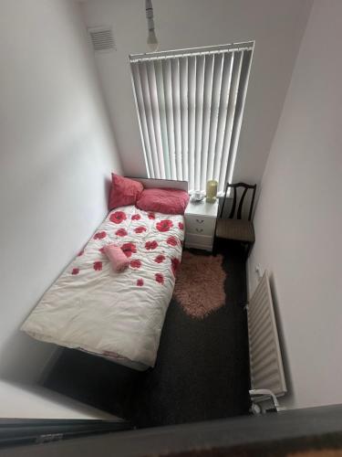 a small bedroom with a bed and a table at Quiet room 5 in Coventry