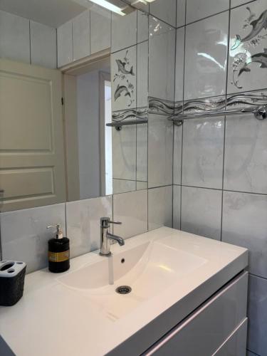 a white bathroom with a sink and a mirror at Villa Cherry in Bar