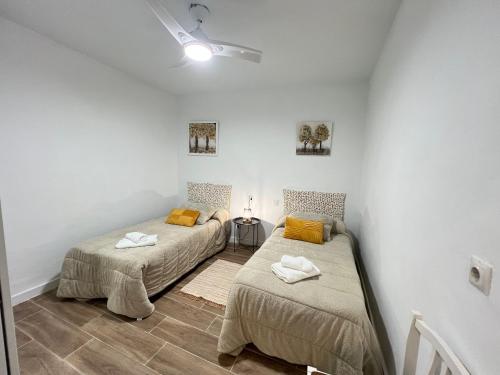 two beds in a room with white walls at Todimer Costa Peñon in Torrenueva