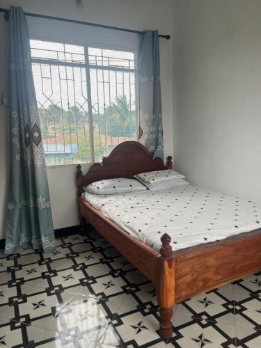 a bed in a room with a window and a bed sqor at Amour Coco Stay in Chaki Chaki