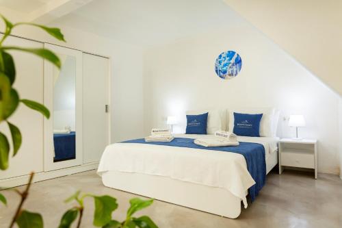 a white bedroom with a blue and white bed at Westcoast Kalkan Suites 1-bedroom suite located heart of Kalkan Old Town in Kalkan