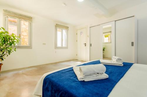 a white room with a blue bed with towels on it at Westcoast Kalkan Suites 1-bedroom suite located heart of Kalkan Old Town in Kalkan