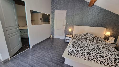 a bedroom with a black and white bed and a mirror at Gerlande 2 in Bourg-Argental