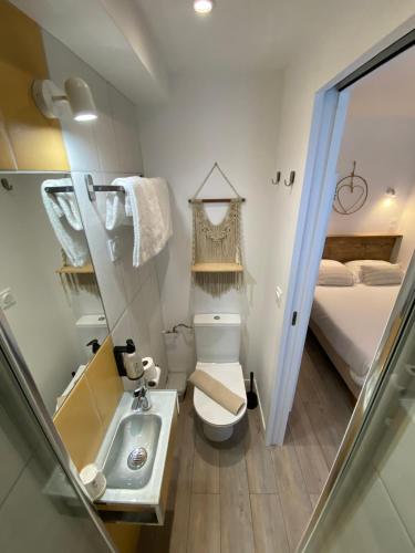 a small bathroom with a toilet and a sink at Hôtel L'Oustaou in Le Lavandou