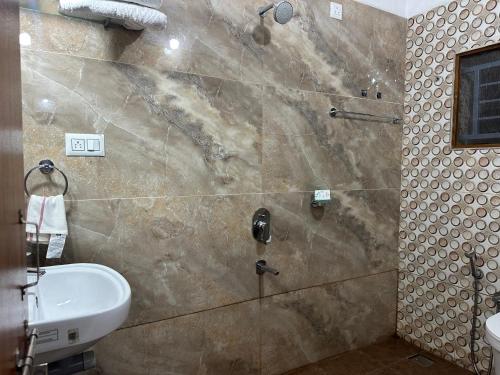 a bathroom with a shower with a sink and a toilet at Joy Villa Homestay in Honāvar