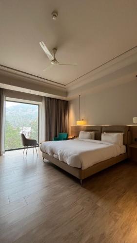 a bedroom with a large bed and a large window at The Supreme Hotel and Banquet in Gaya