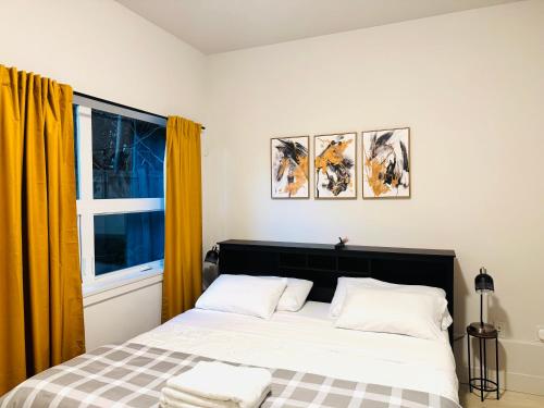 a bedroom with a bed with yellow curtains and a window at Modern Ground Level 1BR Apartment - Prime Location in North Vancouver
