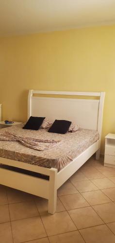 a bed with two pillows on it in a room at Apart savane in São Filipe