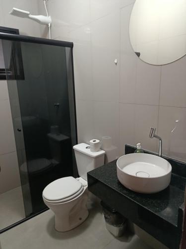 a bathroom with a toilet and a sink at Casa Aconchegante com Espaço Gourmet in Itatiba