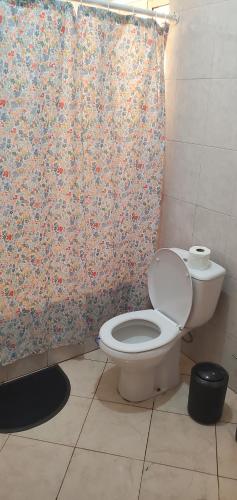 a bathroom with a toilet and a shower curtain at Apart savane in São Filipe