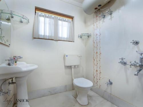 a bathroom with a toilet and a sink and a shower at Luxury Ashok Cottage in Srinagar