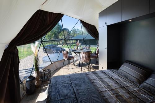 a bedroom with a bed and a table with chairs at Līgo glamping in Stacija Meitene