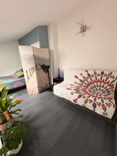 a living room with a bed and a painting on the wall at Villa 4 personnes avec jardinet résidence Le Scarlett in Palavas-les-Flots