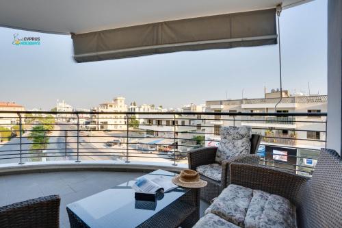 a balcony with chairs and a table with a view at Spacious Modern 3bd Apt in Prestigious Engomi in Ayios Dhometios