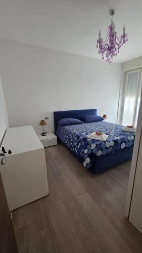 a bedroom with a blue bed and a chandelier at Il Ciano in Sondrio