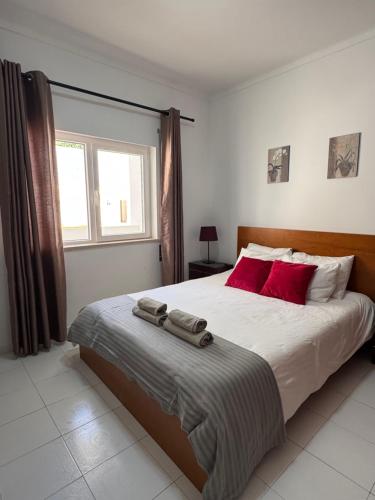 a bedroom with a large bed with red pillows at Cerro Apartment in Carvoeiro